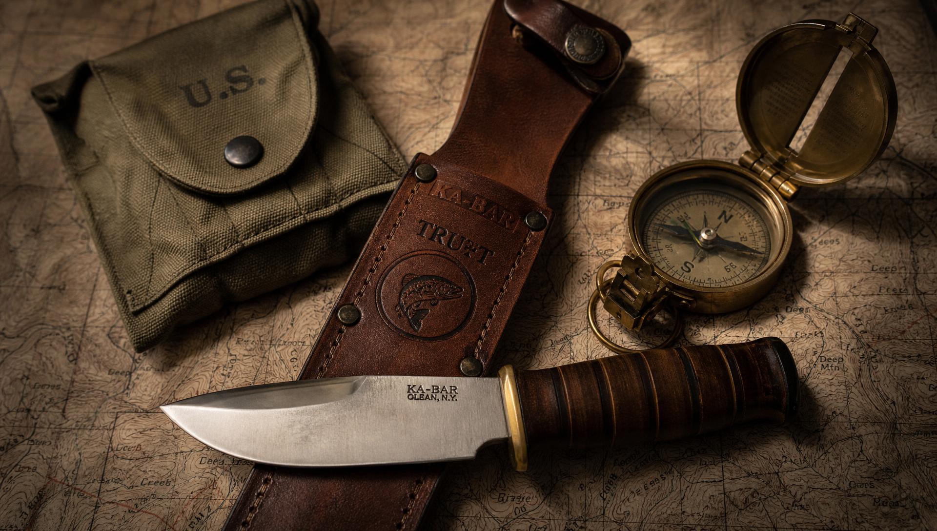 Ka-Bar knife, leather sheath, compass and olive pouch on a topographic map